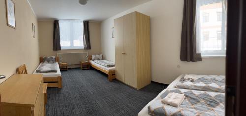クヴィルダにあるApartman na Kvilde - Sumavaのベッド2台、テーブル、椅子が備わる客室です。