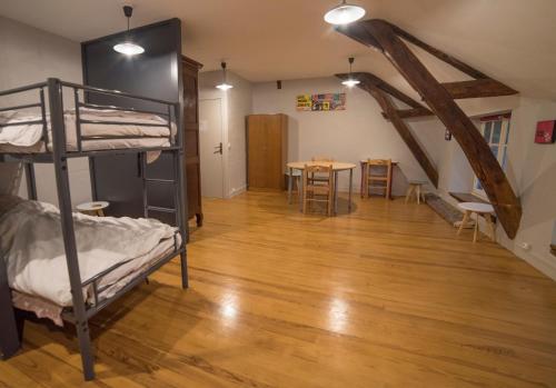 a room with bunk beds and a dining room with a table at INSTITUT BOIS ROBERT in Bécon-les-Granits