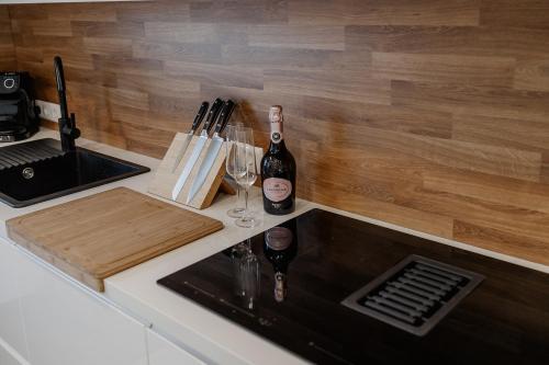 a kitchen counter with a sink and two bottles of wine at Ferienwohnung Leibnitz in Leibnitz