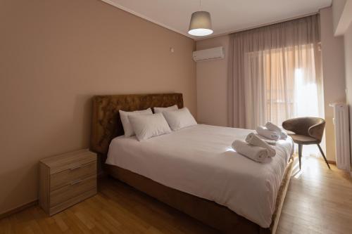 ein Schlafzimmer mit einem Bett mit zwei Handtüchern darauf in der Unterkunft Glyfada downtown in Athen