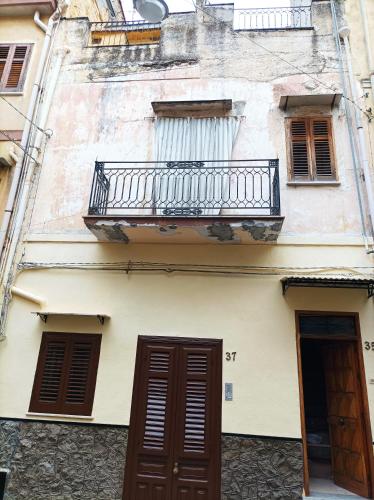 Edificio antiguo con balcón y 2 puertas en Appartamento, en Montelepre