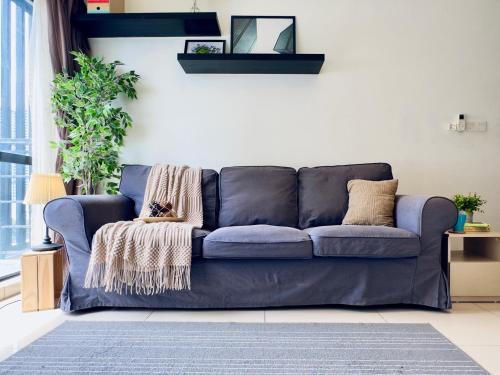 a blue couch in a living room at Cozy Hyve Soho Suites in Cyberjaya