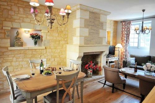 un salon avec une table et une cheminée dans l'établissement GITE DU PRESIDIAL - Standing flat 2 Bed/2 bath with balcony in medieval Sarlat center, à Sarlat-la-Canéda
