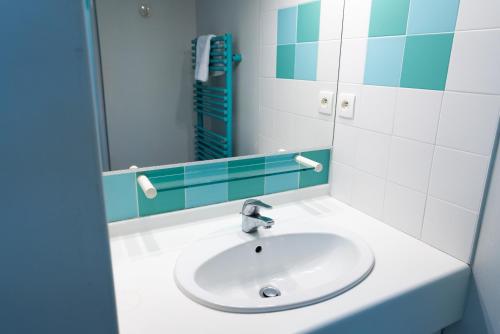 La salle de bains est pourvue d'un lavabo et d'un miroir. dans l'établissement Azureva Tregunc, à Trégunc