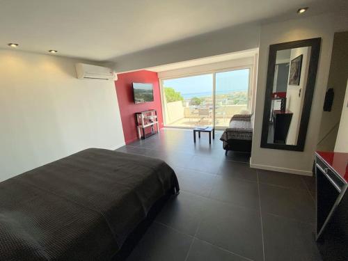 une chambre avec un grand lit et une grande fenêtre dans l'établissement Studio 383, Port Nature 3 au village naturiste, au Cap d'Agde