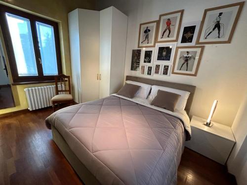 a bedroom with a large bed with pictures on the wall at Valpolicella39 in Verona
