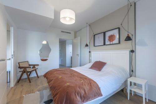1 dormitorio con 1 cama grande y 1 mesa en OVELIA Andrézieux-Bouthéon - Les Demeures du Forez en Andrézieux-Bouthéon