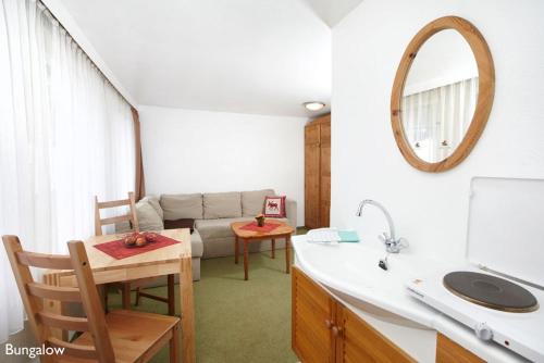 uma cozinha com um lavatório e uma sala de estar com um sofá em Ferienresort Damerow em Ostseebad Koserow