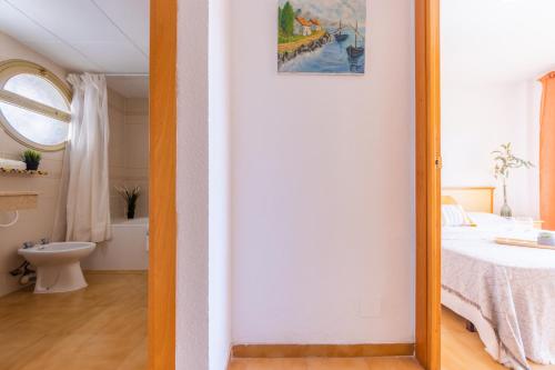 een spiegel in een slaapkamer met een bed en een badkamer bij Córdoba 2 Dormitorios Arysal in Salou