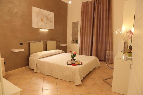 アグリジェントにあるLa Terrazza sulla Valleのテーブルに花を飾ったベッドが備わるホテルルームです。