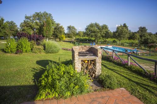 a stone fireplace in a park with a swimming pool at Tenuta Angelici Winery Casa Contea with pool and panoramic pool Cortona in Terontola