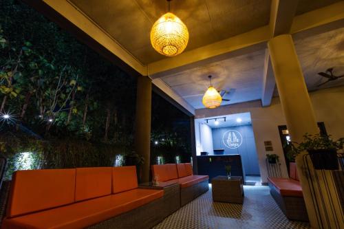 a lobby with orange benches and lights in a building at Vanya in Bengaluru