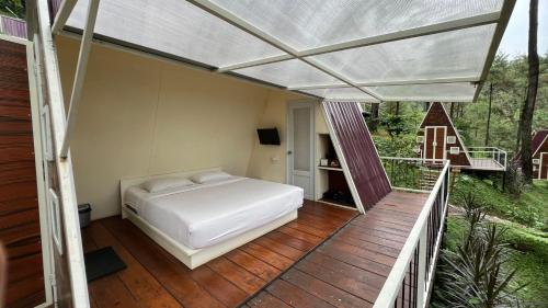 a bedroom with a bed on a deck at Locca Lodge in Mojokerto