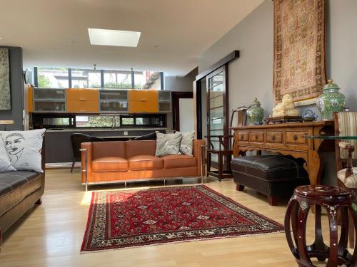 uma sala de estar com um sofá e uma mesa em Oasis On Lily Northcliff em Joanesburgo