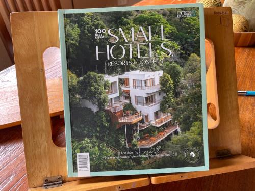 uma revista em cima de uma mesa de madeira em Turtle Bay Eco Luxe Hua Hin em Khao Tao