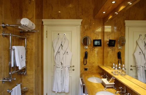 uma casa de banho com um lavatório e um espelho grande em Hotel de la Ville Monza - Small Luxury Hotels of the World em Monza