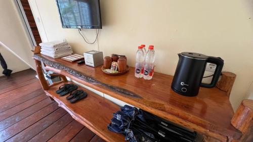 a counter with a coffee maker and water bottles on it at Locca Lodge in Mojokerto
