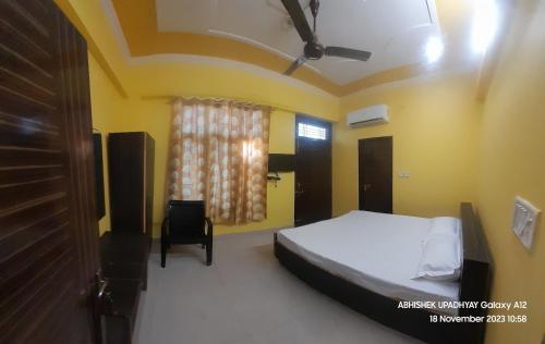 ein Schlafzimmer mit einem Bett, einem Stuhl und einem Fenster in der Unterkunft THE KNIGHTS INN in Lucknow