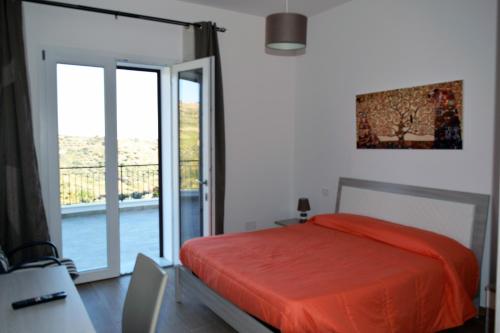 Camere Granatelli في ألتافيلا ميليتشا: غرفة نوم بسرير وباب زجاجي منزلق