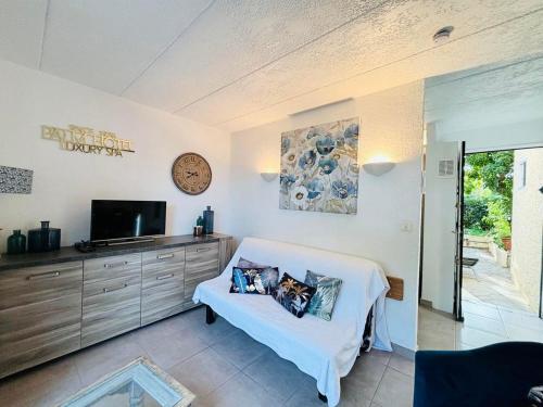 un salon avec un canapé blanc et une télévision dans l'établissement Appartement Solane 4 Lumio, à Lumio