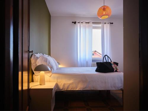 a bedroom with a bed with a window and a lamp at Appartamento Filippo in Baveno