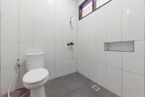 a white bathroom with a toilet and a shower at RedDoorz near Taman Kota Lapang Merdeka Sukabumi in Sukabumi