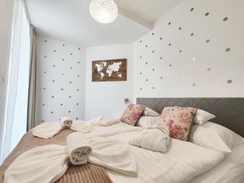 a bedroom with a large bed with white sheets at Spa Residence Carbona EmDoNa Luxury Apartment in Hévíz