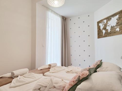 a bedroom with two unmade beds in front of a window at Spa Residence Carbona EmDoNa Luxury Apartment in Hévíz