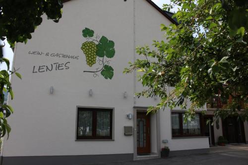 a white building with a sign on the side of it at Wein- und Gästehaus Lentes in Trittenheim