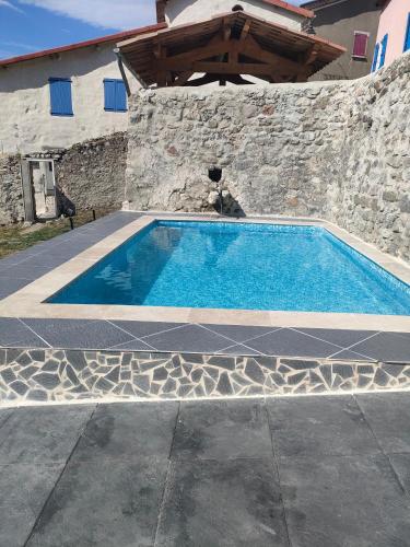 uma piscina em frente a um edifício de pedra em La grande fistoire d'Annie 