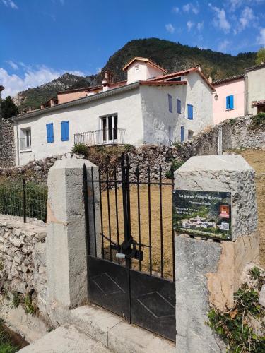 um portão em frente a uma casa branca em La grande fistoire d'Annie 