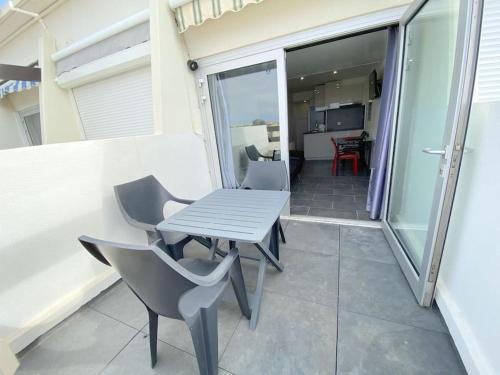 un patio avec une table et des chaises sur un balcon dans l'établissement Appartement 88, Port Nature au village naturiste, au Cap d'Agde