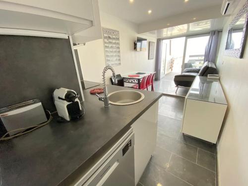 une cuisine avec un évier et un plan de travail dans l'établissement Appartement 88, Port Nature au village naturiste, au Cap d'Agde