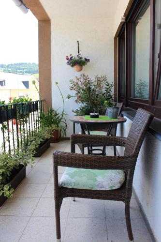 a wicker chair and a table on a balcony at Wein- und Gästehaus Lentes in Trittenheim