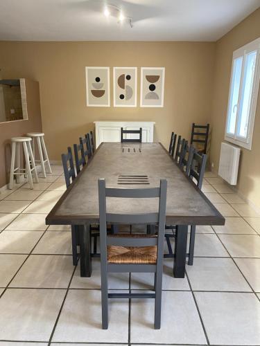 a dining room with a wooden table and chairs at Villas de La Ferme Du Gros Noyer in Malaucène