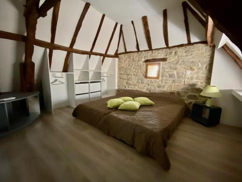 ein Schlafzimmer mit einem Bett mit zwei Kissen darauf in der Unterkunft La Grange de Camille in Loupiac