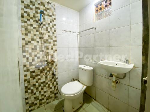 a bathroom with a toilet and a sink at Audah Guesthouse Syariah Kuningan RedPartner in Jakarta
