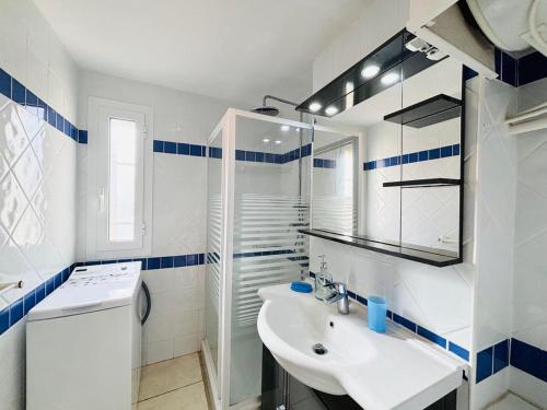 La salle de bains blanche est pourvue d'un lavabo et d'un lave-linge. dans l'établissement Appartement Aria Marina 2 Lumio, à Lumio