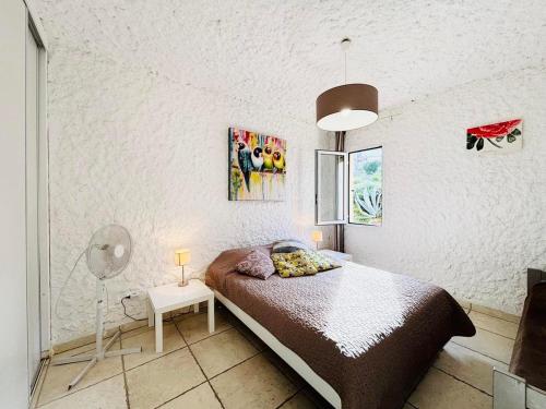 une chambre avec un lit et un mur blanc dans l'établissement Appartement Aria Marina 2 Lumio, à Lumio
