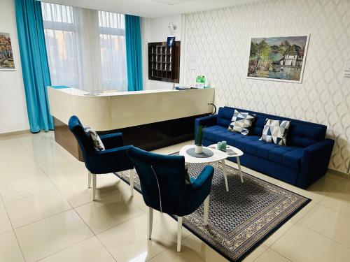 a living room with a blue couch and a piano at HOTEL MINERO in Tuzla