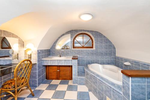Pension Nostalgie في تشيسكي كروملوف: حمام من البلاط الأزرق مع حوض استحمام ومغسلة