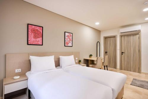 a bedroom with a large white bed and a table at Brassbell l New Cairo l next to AUC in Cairo