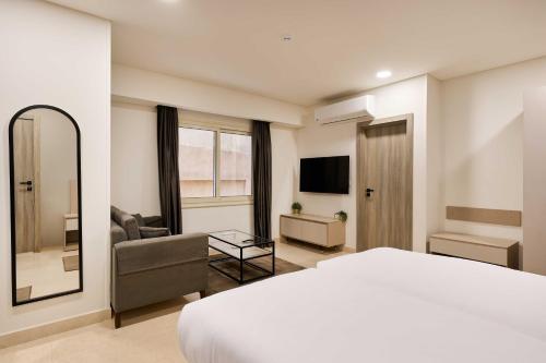 a bedroom with a bed and a living room at Brassbell l New Cairo l next to AUC in Cairo