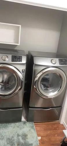 a washing machine and a washer and dryer in a room at Spruce Lodge in London