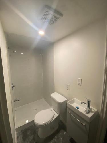 uma casa de banho branca com um WC e um chuveiro em Spruce Lodge em London