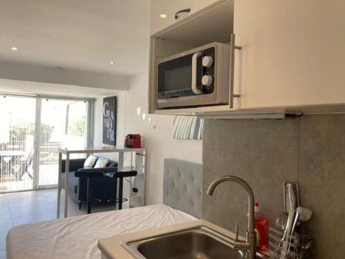 une cuisine avec un évier et un micro-ondes dans l'établissement Studio 20, Port Nature 2 au village naturiste, au Cap d'Agde