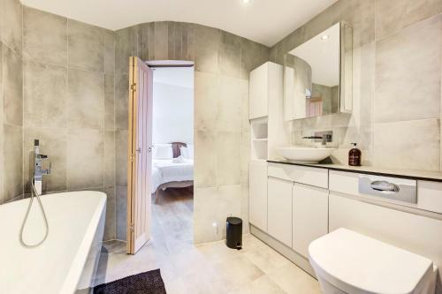 La salle de bains est pourvue d'une baignoire, de toilettes et d'un lavabo. dans l'établissement Duplex Apartment Shoreditch - the Living Elite Collection, à Londres