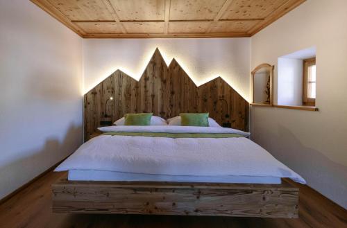 Schlafzimmer mit einem Bett mit einem Kopfteil aus Holz in der Unterkunft Chalet 1593 in Vandans