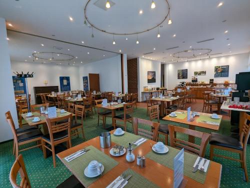 a dining room with wooden tables and chairs at Acron-Hotel Quedlinburg in Quedlinburg