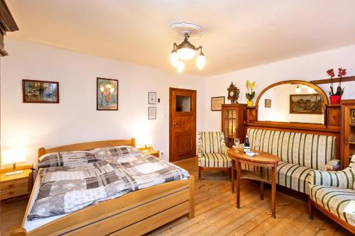 - une chambre avec un lit, une table et un canapé dans l'établissement Pension Nostalgie, à Český Krumlov